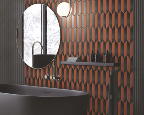 Bathroom with bathtub, mirror and accessories, showing red and black mosaic tiles.